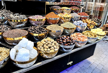 An array of vibrant spices and dried fruits arranged in open bowls and baskets, evoking the richness of culinary traditions