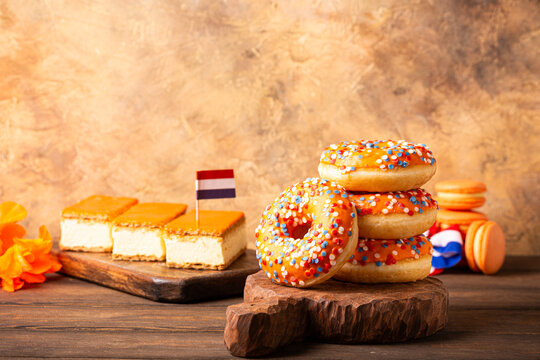 Glazed Orange Dutch desserts tompouce and donuts for event Kings day. National holiday Koningsdag on 27 April in the Netherlands. Holland culture concept with copy space