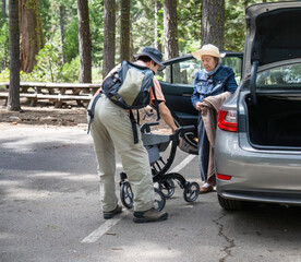 Man taking out mobility walker from car boot and setting up for elderly mother. Lake Tahoe....