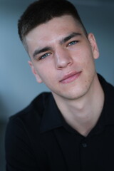 Obraz premium Asian 20s man portrait close up. Chinese guy look camera coworking background. Japanese person smile. Young korean male t-shirt. Adult thai people face. Nice freelancer. Serious brunette work China.