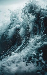A close-up of a crashing wave, with white foam and blue water. The water is turbulent and powerful, with a sense of energy and movement.