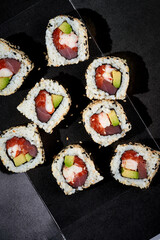 A set of maki rolls with salmon, cucumber, shrimp in a black package. Photo for delivery