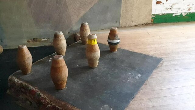 Close up of skittles wooden pins being hit over on alley during a traditional English pub game