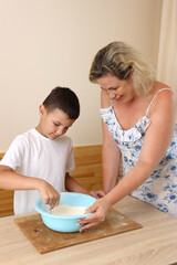 Mother and son prepare pizza dough. Cooking at home.