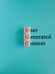 UGC user generated content symbol. Concept red words UGC user generated content on wooden cubes. Beautiful blue background. Business and UGC user generated content concept.