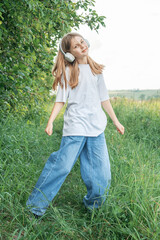 Fototapeta premium A child with headphones listening to music and dancing
