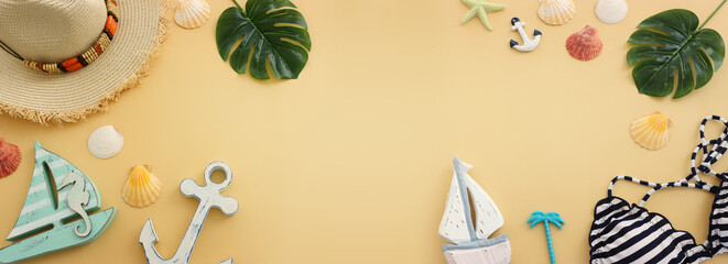 Top view of female swimsuit bikini, sea shells over pastel yellow background. Summer beach vacation concept