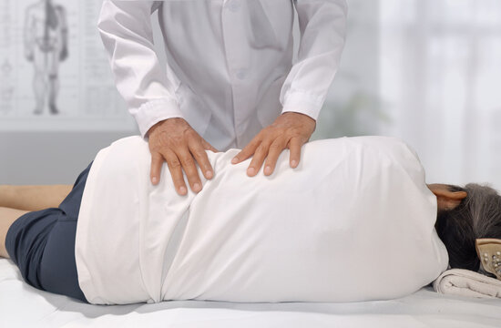 허리통증으로 인해 의사에게 허리 도수치료를 받는 환자 _  추나요법 