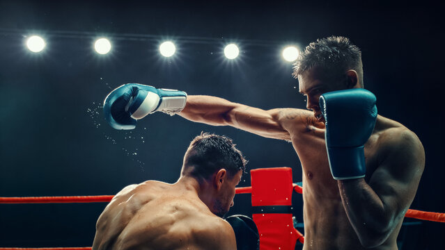Two Male Boxers in an Electrifying Match, One Delivering Powerful Punch Under Bright Lights. Intensity and Raw Energy of the Fight Are Captured, With Sweat Flying Off Their Bodies. Boxing Championship