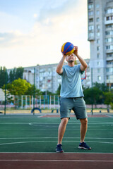 Middle aged man playing basketball on city court