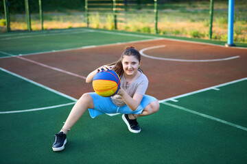 Fototapeta premium Lifestyle portrait of Cheerful caucasian little girl ten years old holding game ball