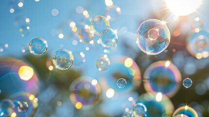 Shiny, iridescent soap bubbles floating in the air, reflecting rainbow colors under the sunlight, against a clear blue sky.