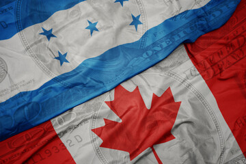 waving colorful flag of honduras and national flag of canada on the dollar money background. finance concept.