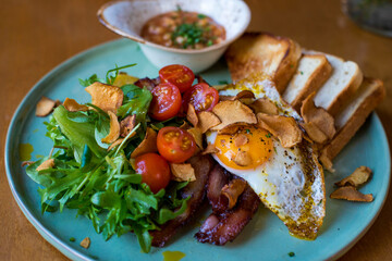 Cooking at home consisting of fried eggs, vegetables and tomatoes.