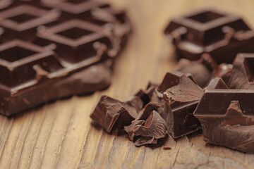 Dark chocolate that is broken on the wood floor.