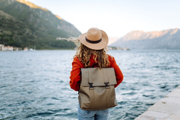 Back view young woman tourist admiring view of colorful the view of the city and view of the mountain bay. Lifestyle, vacation, rest, active life.
