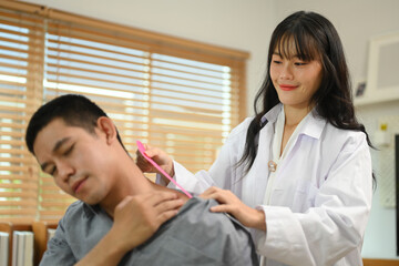 Obraz premium Physiotherapy specialist applying kinesio tape on the shoulders and neck of athlete patient. Sport physical therapy concept