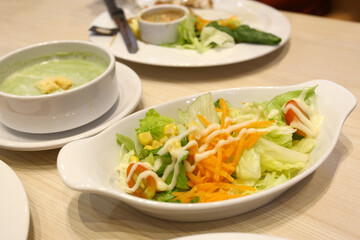 Tuna salad is served on a white plate on the dining table.