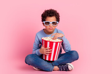 Full length photo of moody funny grandson wear blue pullover watching movie enjoying pop corn emtpy space isolated pink color background