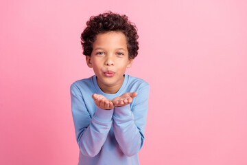 Photo of handsome good mood grandson wear blue sweater sending you kiss emtpy space isolated pink color background