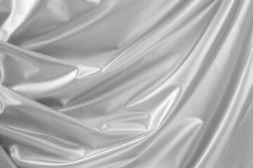 Metallic silver fabric texture with folds, abstract patterned backdrop