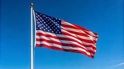 Obraz premium A lone flag waves proudly in the wind, attached to a sturdy pole standing tall against a clear blue sky.
