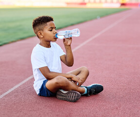 child sport athlete exercise running water bottle drink drinking refreshment thirsty resting plastic break active young childhood fitness jogging training athletic