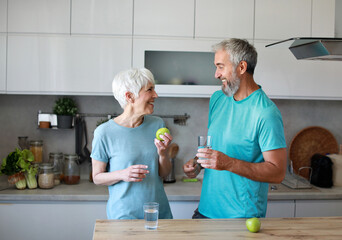 kitchen food woman healthy couple senior mature active fitness diet home eating adult lifestyle fruit sport fit health preparation breakfast nutrition apple glass drink
