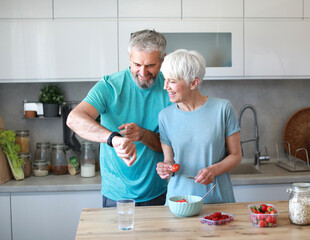 kitchen food woman healthy couple senior mature active fitness diet home eating adult lifestyle fruit sport fit health preparation breakfast nutrition smart watch app techology cardio