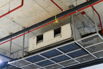 Ceiling mounted cassette type air conditioner in factory hall.