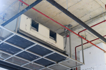 Ceiling mounted cassette type air conditioner in factory hall.