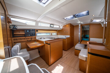 Sailing yacht interior. Double cabin on a charter yacht. Bareboat yacht interior - wood trim, light...
