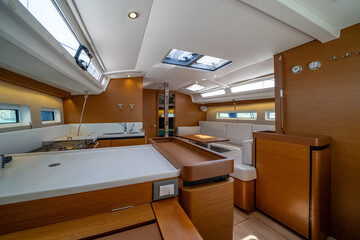 Sailing yacht interior. Double cabin on a charter yacht. Bareboat yacht interior - wood trim, light mattress and bedding, plenty of light from portholes. Comfortable berth for cruise on seas, oceans