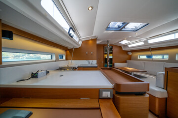 Sailing yacht interior. Double cabin on a charter yacht. Bareboat yacht interior - wood trim, light mattress and bedding, plenty of light from portholes. Comfortable berth for cruise on seas, oceans