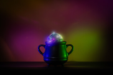 Creative minimalist Halloween image featuring a witch cauldron with a glowing disco ball. Perfect for modern and trendy Halloween designs.