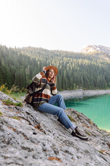 Naklejka premium Female traveler enjoying the view of Lake among mountains. Eco tourism. Active lifestyle.