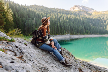 Female traveler enjoying the view of Lake among mountains. Eco tourism. Active lifestyle.