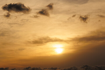 Sun is setting behind the clouds and grey-yellowish cloudy background for the purpose of the web and design uses