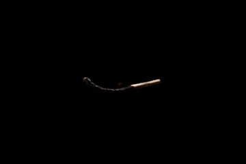 Lit falling match on a black background.