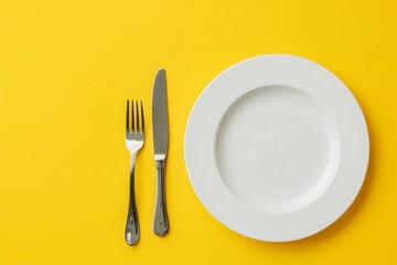 Top down view of a white plate isolated on yellow background