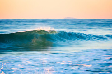 Fototapeta premium Beautiful breaking wave in motion on the shore.