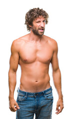 Fototapeta premium Handsome hispanic model man sexy and shirtless over isolated background winking looking at the camera with sexy expression, cheerful and happy face.