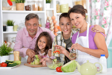 Portrait of beautiful family cooking at kitchen