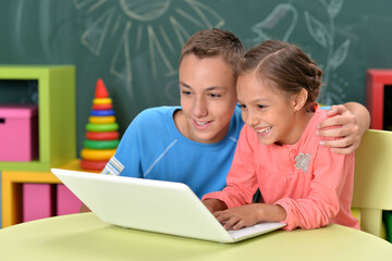 Portrait of brother and sister using laptop 