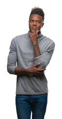 Fototapeta premium Young african american man over isolated background looking confident at the camera with smile with crossed arms and hand raised on chin. Thinking positive.