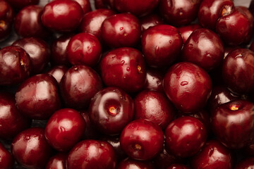 juicy, delicious cherries in a splash of water on a dark background.