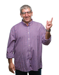 Naklejka premium Handsome senior man wearing glasses over isolated background with a big smile on face, pointing with hand and finger to the side looking at the camera.