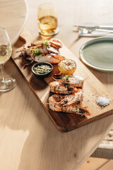 Shrimps grilled, prawns served with lime and sauce on a restaurant table wooden. Seafood.