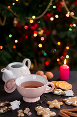 Cup of tea with Christmas cookies, hungarian christmas candy and walnut, cinnamon and burning candle. 