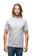 Young handsome man with long hair over isolated background with serious expression on face. Simple and natural looking at the camera.